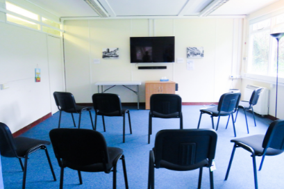 A small teaching room with black chairs